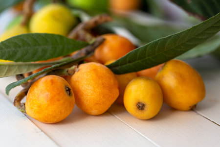 fresh loquats on white wooden backgroundの写真素材