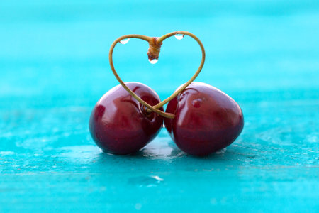 a pair red cherry with heart shapedの写真素材