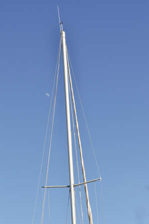 Blue sky, sunny summer day and white lines. Part of sailboat and small white moon. Minimal Summer composition.の写真素材