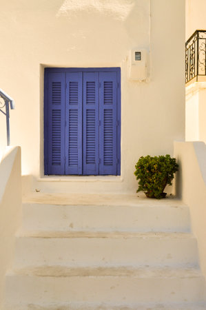Island white architecture with blue window and plant. Minimal composition. Summer inspiration.の写真素材