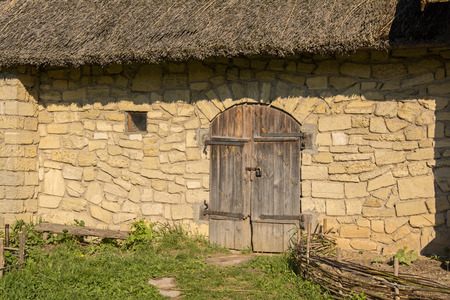 brick house with wooden door closed on the lockの写真素材