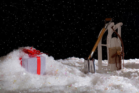 New Year's gift in a snowdrift. Sledge and a shovel. Night, snowfallの写真素材