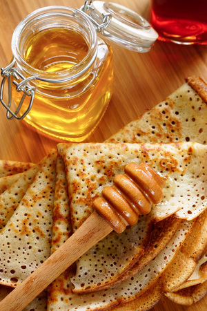 Pancakes with honey. Maslenitsa.Traditional Russian pancakes and a jar of honey.の写真素材