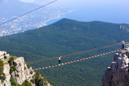 Alupka, Crimea - September 21, 2018. Suspended stairs on Mount Ai-Petri. Crimea. Tourists walk along the hanging stairs between the teeth of Ai-Petri. On the horizon Yalta.のeditorial素材