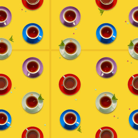Tea in colorful cups. Seamless background with multi-colored cups with tea. Yellow background. View from aboveの写真素材