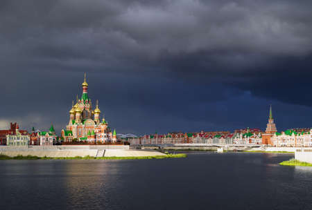 Yoshkar-Ola, Mari El, Russia - September 5, 2021. Cathedral of the Annunciation of the Most Holy Theotokos. Built in 2010-14. Voskresenskaya embankment. The cathedral is illuminated by the sun through thunderclouds.のeditorial素材