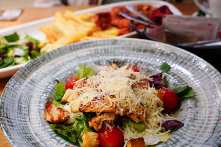 Caesar salad with chicken and cheese in a round gray plate. Shallow depth of fieldの写真素材