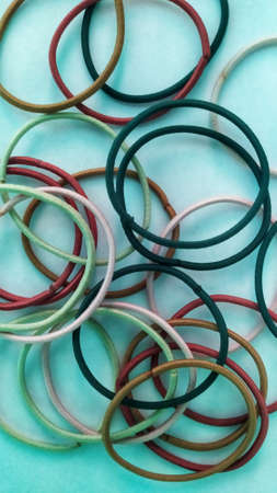Variety of colorful rubber bands on a blue background. Top view.