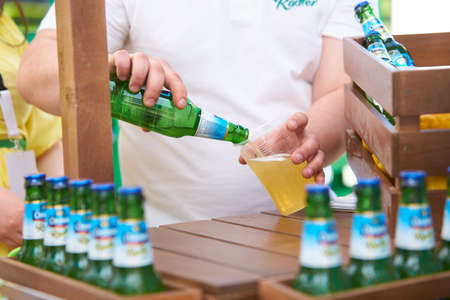 CHISINAU/MOLDOVA - 04.17.2016: Chisinau Radler Zero beer bottle between exotic whole lemon fruits and wooden crate. Beer bottles in a row, arranged in a wooden box. Green, yellow and brown backgroundのeditorial素材