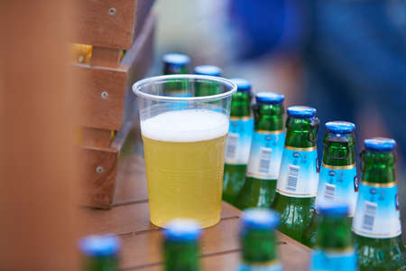 CHISINAU/MOLDOVA - 04.17.2016: Chisinau Radler Zero beer bottle between exotic whole lemon fruits and wooden crate. Beer bottles in a row, arranged in a wooden box. Green, yellow and brown backgroundのeditorial素材