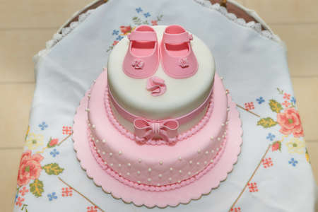 Baby special birthday pink cake on the table. Kids birthday party decoration and cake.