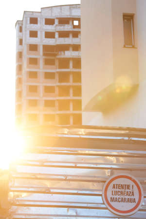An abandoned multi-storey building with inscription attention, the crane works. Multi-storey...