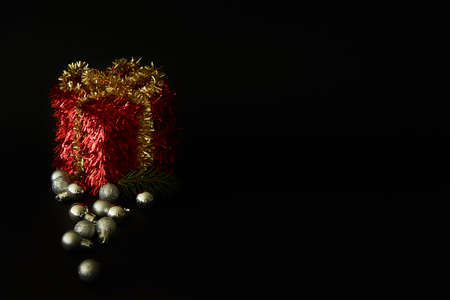 Noel design. White gift box with ribbon and New Year balls  on dark dark background. Xmas backdrop with space for text.の写真素材