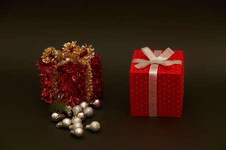 Red gift boxes with yellow ribbon and New Year balls on dark dark background. Xmas backdrop with...