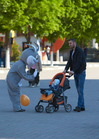 Aactors in a rabbit costume play with baby an public event.