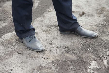 Pair of old dirty leather business shoes isolated on the ground background. Dirty shoes