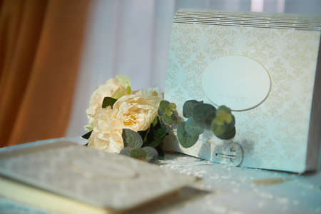 wedding elements, guest book and mini bouquet flowers on table. blue background.の写真素材