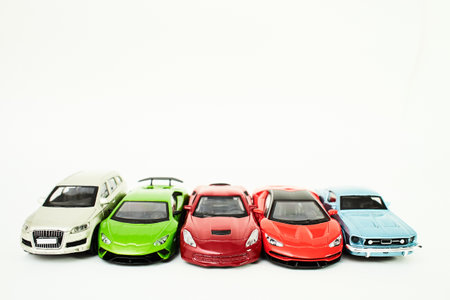 Many multi-colored toy cars on white background. The group of car toy. Small cars on white table, top view with copy space.の写真素材