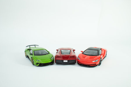 Many multi-colored toy cars on white background. The group of car toy. Small cars on white table, top view with copy space.の写真素材