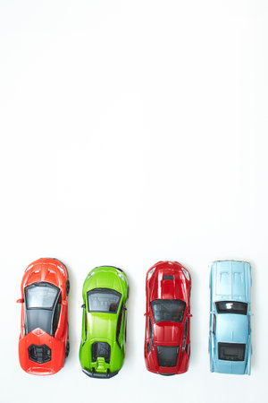 Many multi-colored toy cars on white background. The group of car toy. Small cars on white table, top view with copy space.の写真素材