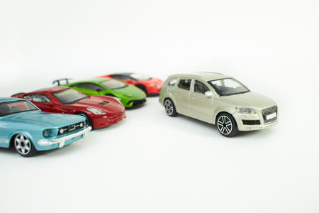 Many multi-colored toy cars on white background. The group of car toy. Small cars on white table, top view with copy space.の写真素材