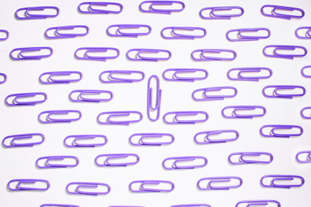 Purple paper clips on a white background close up. Textureの写真素材