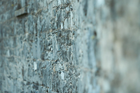 Pattern gray color of modern style design decorative uneven cracked real stone wall surface with cement.の写真素材