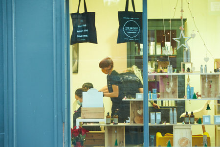 Working during covid-19 or coronavirus concept. A professional hairdresser cutting the hair to a client.のeditorial素材