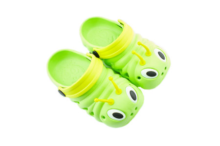 Pair of bright green children's clogs isolated on the white background.