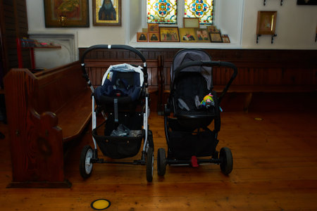 Two empty strollers in the church at baptism. Orthodox tradition in Europe.のeditorial素材