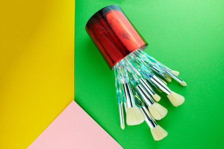 Professional makeup brushes for face isolated on pink, yellow and green background.