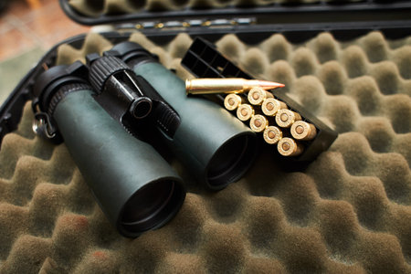 Binocular and bullets on the dark background.の写真素材