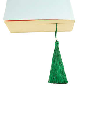 A detail of a closed book with a bookmark, isolated on pink background.の写真素材