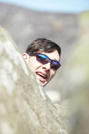 Young man in hoodie with joyful expression. People sincere emotions lifestyle concept. Nature in background.の写真素材