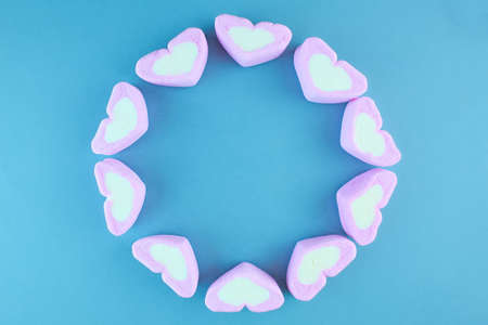 Pink heart-shaped marshmallow isolated on blue background.の写真素材