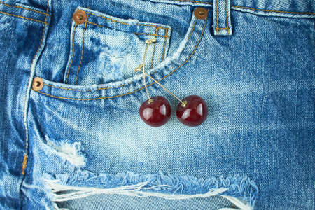 Denim jeans blue cloth with front pocket and cherry earrings.の写真素材