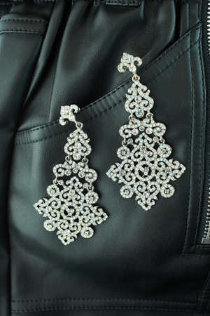 Wedding earrings on black skin cloth background.の写真素材