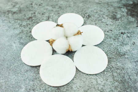 Cotton flowers with soft makeup pads on grunge cement texture background.の写真素材