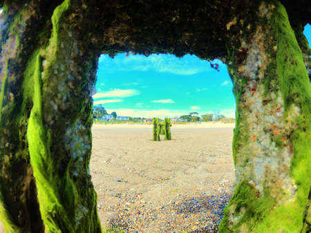 Sandy beach and archs with green moss on the daytime.の写真素材