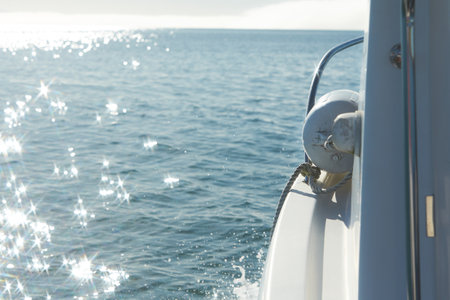 Part of the boat with sunlight reflecting in glittering sea. Sparkling in water - background. Sea...