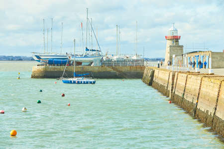 Pier with white lighthouse in Howth, Ireland.の写真素材