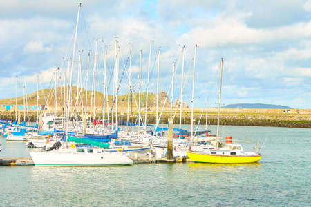 Boats in harbor with blue colorful cloudy sky in background.のeditorial素材