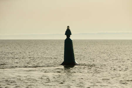 A marker buoy floating in the sea. beacon. Sunny afternoon.