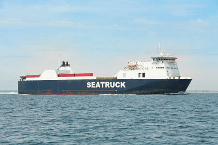 Huge container tanker ship carrying truck size colourful containers in deep blue open ocean seaの写真素材