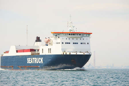 Huge container tanker ship carrying truck size colourful containers in deep blue open ocean seaの写真素材