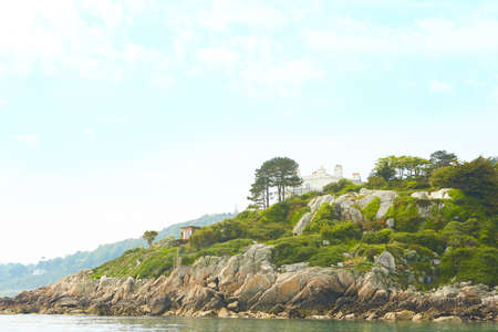 View from the sea to the county of Dalkey, Ireland with green trees and blue sky.の写真素材