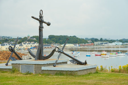 Old naval fortifications and cannons with rusty anchor as landmark and tourist attraction in Wicklow port and village in background, Ireland.の写真素材