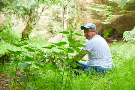 A caucasian disability man resting in the bright green fresh forest.の写真素材