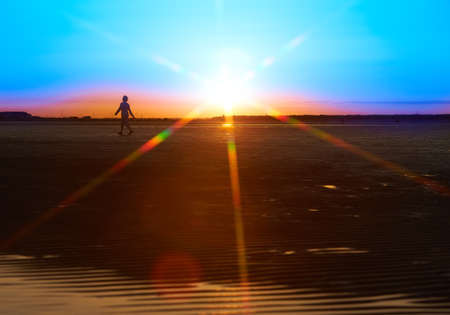 Beautiful sandy beach with bright reflected blue sky at sunset.の写真素材