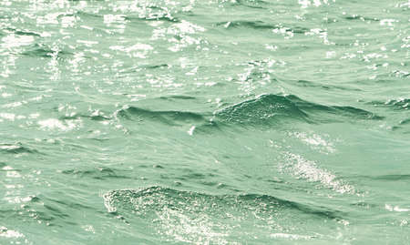 Detail of a sunlight reflecting in glittering sea. sparkler in water - background. sea water with sun glare and ripple. Powerful and peaceful nature concept.の写真素材